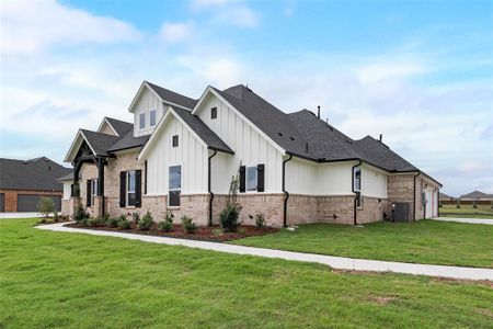 View of front of house with a garage, central AC unit, and a front yard