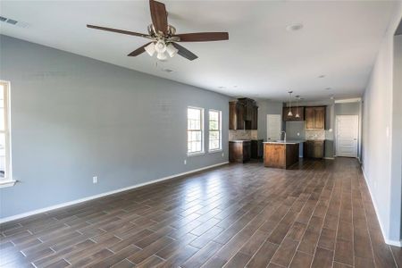 Kitchen featuring decorative backsplash, a center island, dark hardwood / wood-style floors, sink, and pendant lighting