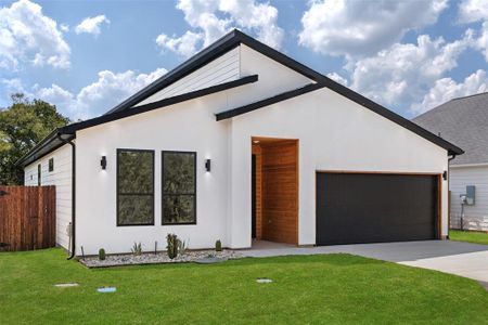 View of front of house featuring a garage and a front lawn