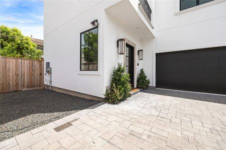 Gas lanterns highlight the home's facade and complement the contemporary glass entrance. Additionally, this residence features a coveted additional parking space to the left of the property, along with a two-car attached garage.