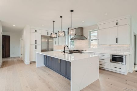 Chef's kitchen showcasing a massive quartz waterfall island