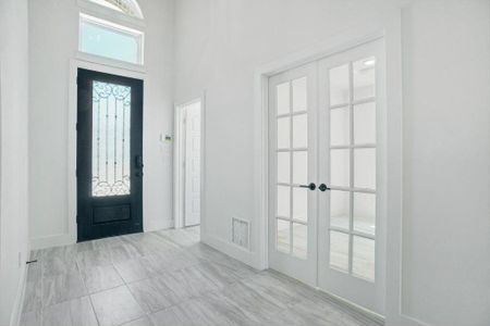 Foyer with french doors and a high ceiling