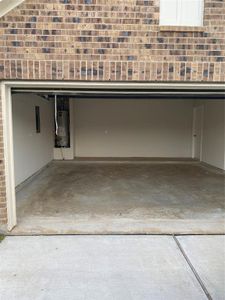 Large two car garage with large hot water heater.