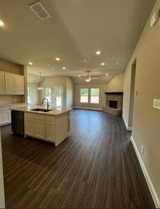 Kitchen featuring black dishwasher, a kitchen island with sink, sink, and white cabinets