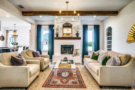 Living room featuring beam ceiling, an inviting chandelier, and light wood-type flooring