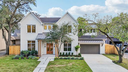 The elevation design elements such as standing seam roof features, brick siding coupled with smaller vertical hardi sections, a classic stained wood double door entry, and stately Cedar columns come together to make the home textured and interesting from the street.