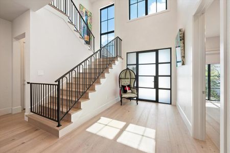 Entrance foyer featuring light wood-type flooring and a towering ceiling