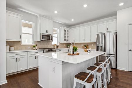 Quartz countertops, cushion close cabinets, trash roll out cabinet, crown molding, GE upgraded line of appliances, subway tile backsplash, extra deep kitchen island, farmer's sink, kitchen faucet includes sleek motion sense one-handle pulldown spot resist stainless.