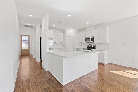 Kitchen featuring appliances with stainless steel finishes, white cabinetry, and dark wood-type flooring