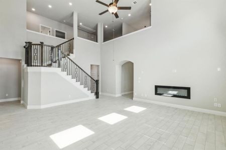 Unfurnished living room with a high ceiling and ceiling fan