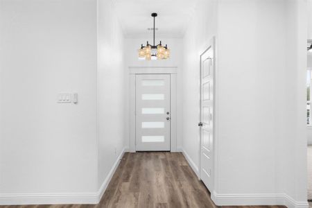 Entrance foyer with wood-type flooring and ornamental molding