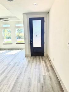 Doorway to outside featuring light wood-type flooring and ceiling fan