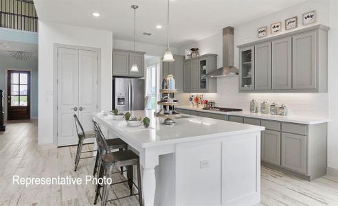 Kitchen with tasteful backsplash, stainless steel appliances, gray cabinets, wall chimney range hood, and a center island