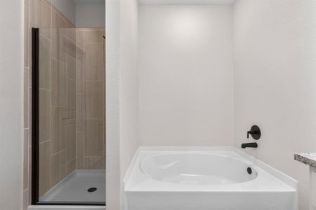 Step into the luxurious en-suite bathroom, where a sleek vanity offers both style and functionality, while a separate tub and shower combo provide the ultimate in relaxation and convenience.