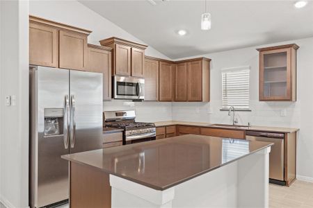 Adjacent to the island and throughout the kitchen, expansive countertops offer abundant workspace. They are designed for practicality, providing sufficient room for appliances like a coffee maker, toaster, or stand mixer, while leaving ample room for meal preparation and serving.