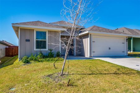 Ranch-style home featuring a garage and a front lawn