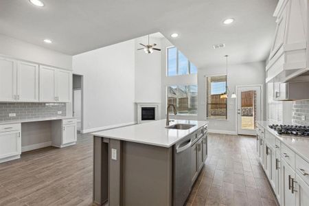 Kitchen with hardwood / wood-style flooring, sink, white cabinets, a center island with sink, and appliances with stainless steel finishes