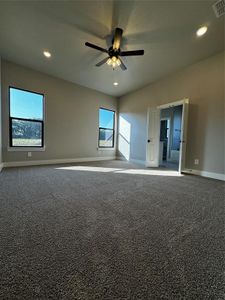 Carpeted spare room with ceiling fan