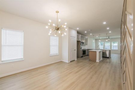 Kitchen featuring sink, stainless steel appliances, pendant lighting, light hardwood / wood-style floors, and a kitchen island