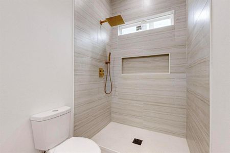 Bathroom with toilet and tiled shower