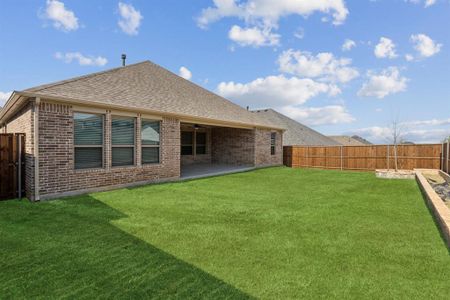 Rear view of property with a lawn and a patio