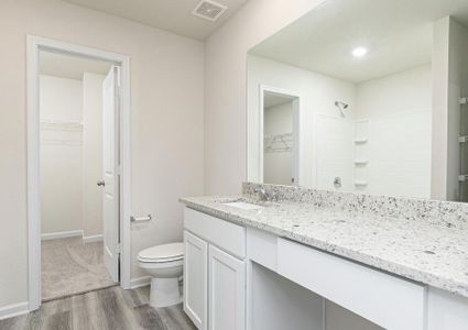 The attached master bathroom includes an expansive vanity