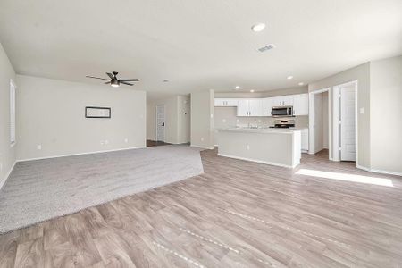 Unfurnished living room with light wood-type flooring and ceiling fan