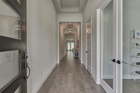 Foyer with soaring ceilings showcases the continuous engineered wood flooring which runs throughout the first floor of this home!