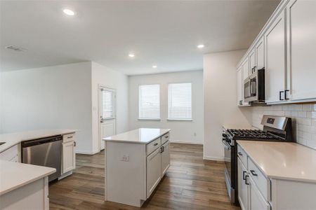 Kitchen featuring white cabinets, stainless steel appliances, and a kitchen island