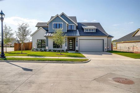 View of front facade featuring a front yard and a garage