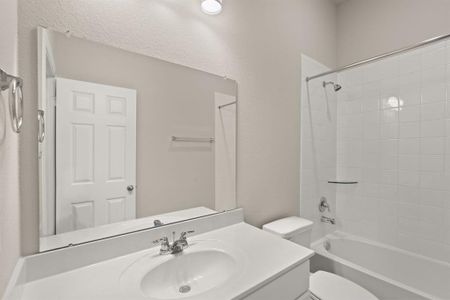 The secondary bath features tile flooring, white cabinetry and light countertops and a shower/tub combo. Perfect for accommodating any visiting family and friends.