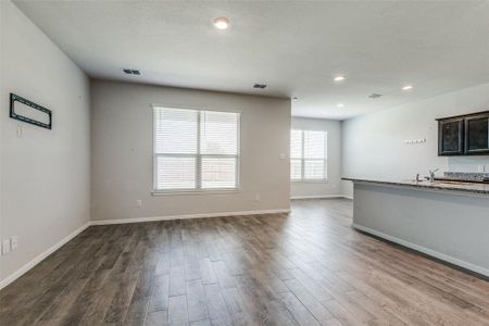 Unfurnished living room with sink and hardwood / wood-style floors