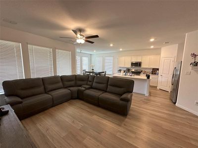 Living room with light hardwood / wood-style flooring and ceiling fan