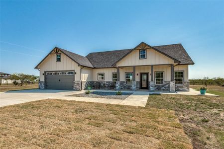 View of front of home featuring a front lawn and a garage