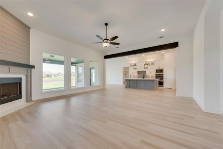 Unfurnished living room with light hardwood / wood-style floors, sink, and ceiling fan