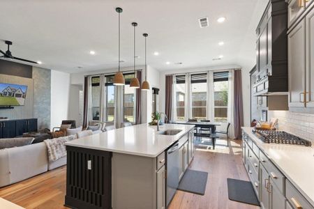 Kitchen featuring light hardwood / wood-style floors, ceiling fan, a center island with sink, and sink