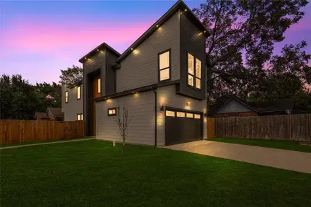 View of front of property with a garage and a lawn