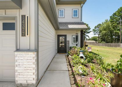 A flower garden enhances the walkway that leads to the upgraded six panel front door!