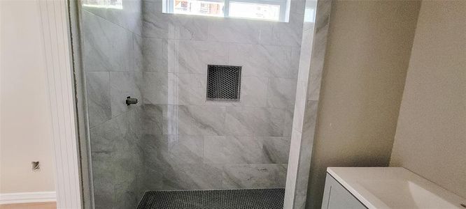 Bathroom featuring vanity and a tile shower