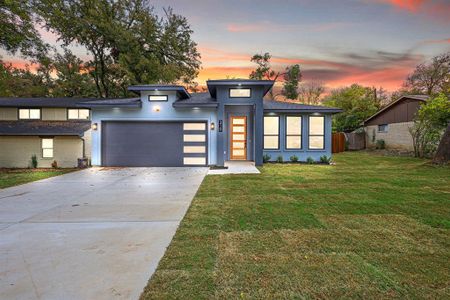 View of front of property with a yard and a garage