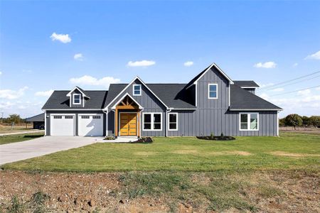 Modern inspired farmhouse featuring a front yard and a garage