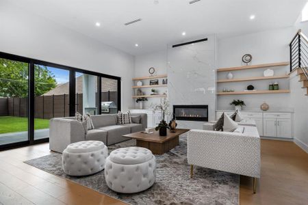 Living room featuring light hardwood / wood-style floors and a high end fireplace