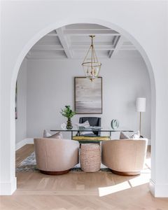 Dining room featuring coffered ceiling, beamed ceiling, light hardwood / wood-style flooring, and a chandelier