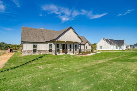 Back of house with a patio and a lawn