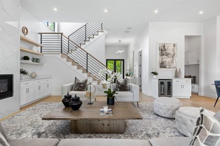 Living room featuring wine cooler, a large fireplace, and light hardwood / wood-style floors