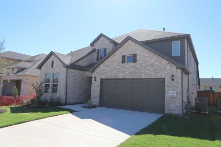 View of front of home with a front yard, cooling unit, and a garage