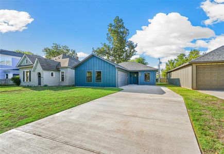 Ranch-style house with a garage and a front lawn