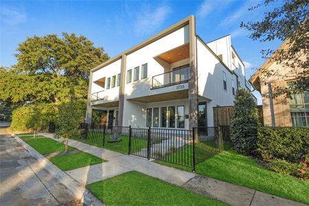 Modern home featuring a balcony and a front lawn