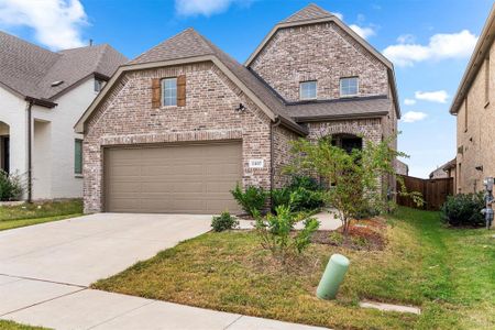 View of front of property featuring a front lawn and a garage