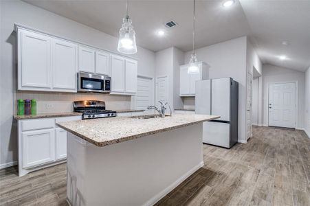 Kitchen featuring white cabinetry, sink, and appliances with stainless steel finishes